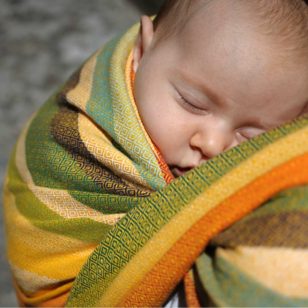 A close up of a baby sleeping in a Girasol woven wrap highlighting the diamond weave nature of the fabric.